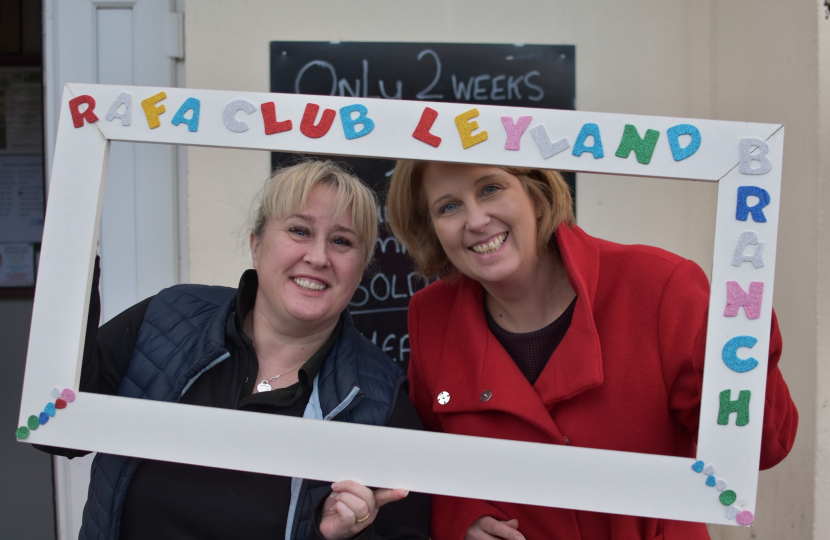 Katherine Fletcher with Kelly, the manager of the RAFA Club. They are holding a fake picture frame around themselves with "RAF Club Leyland" written on it.