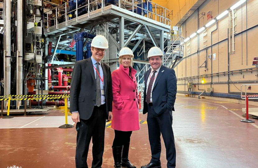 Katherine Fletcher with two others stood in front of industrial machinery