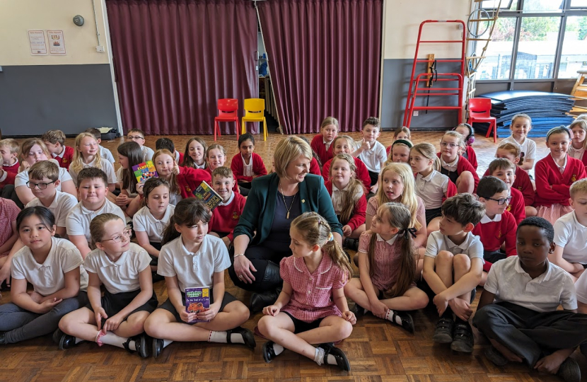 Katherine sitting with children at the school assembly