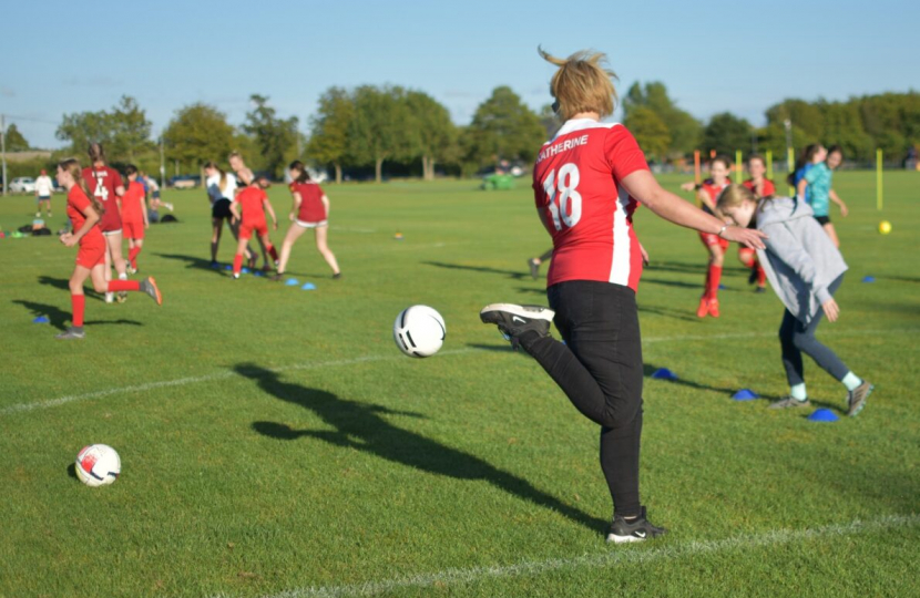 Katherine playing football in football tshirt with her name on the back