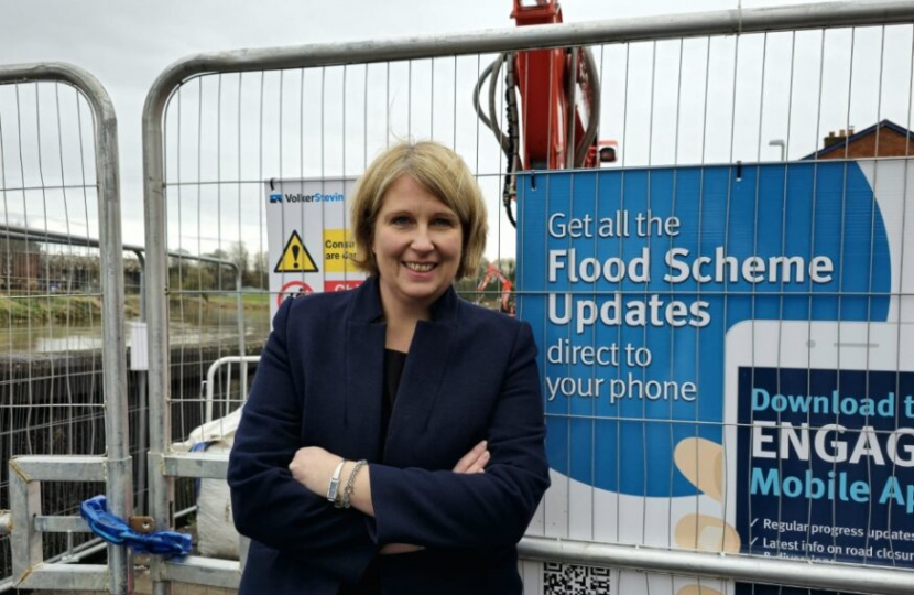 Katherine standing in front of flood scheme update sign in penwortham