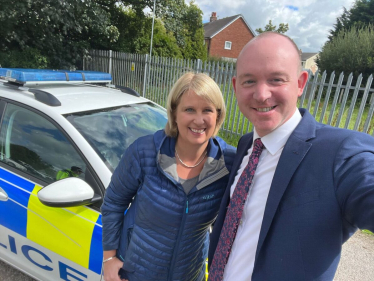 Katherine standing beside a police car with Andrew Snowden