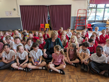 Katherine sitting with children at the school assembly