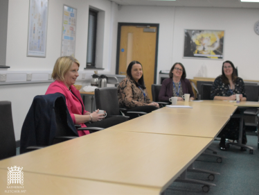 Katherine Fletcher sat at a desk at Runshaw College, talking to staff members and students.