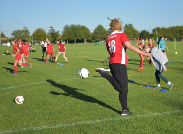 Katherine playing football in football tshirt with her name on the back